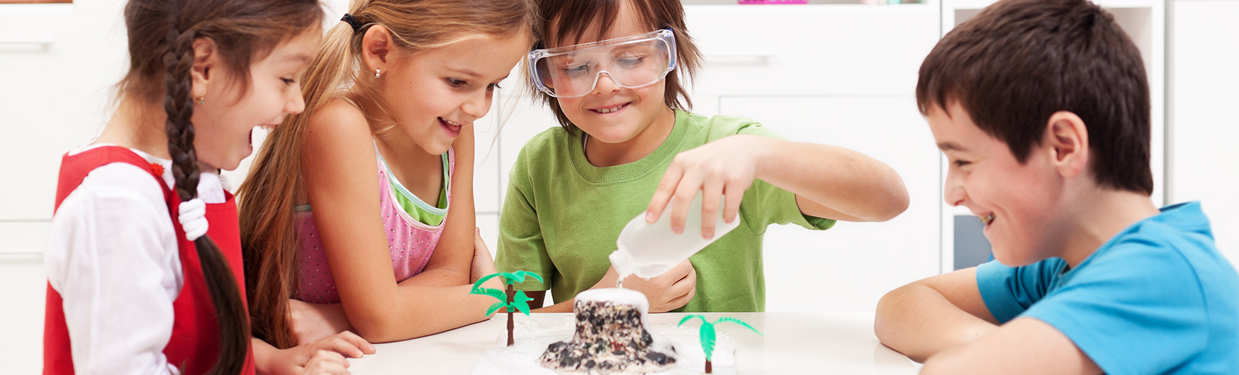 Kindgerechtes Lernen - Wissensvermittlung macht Spaß Kinder sitzen gemeindsam am Tisch und experimentieren