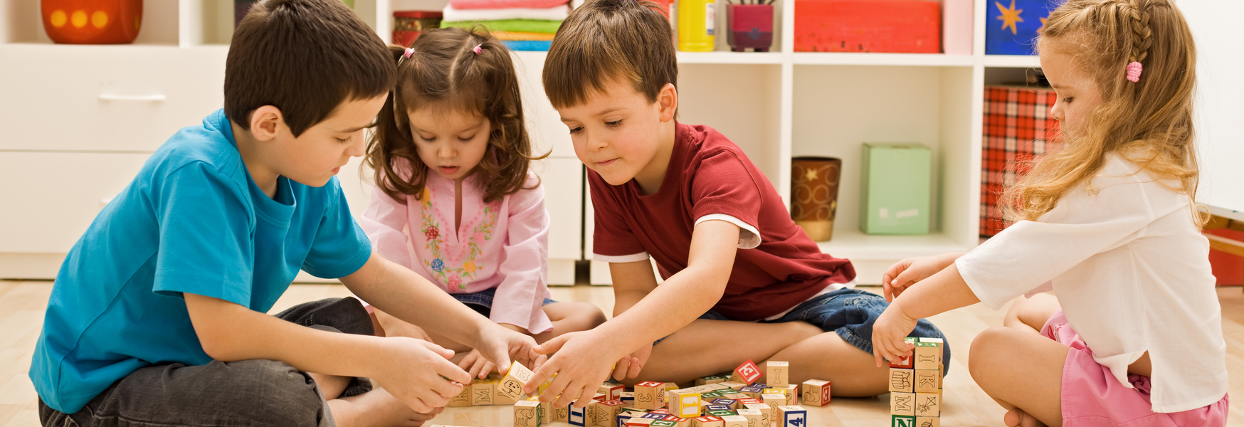 Darum ist das Spielen für Kinder so wichtig Kinder sitzen im Kreis und spielen gemeinsam