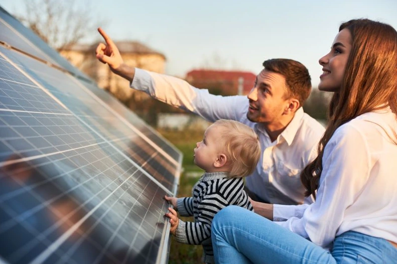 Eine Familie beobachtet die Solaranlage, die auf dem Dach ihres Eigenheims installiert wird.