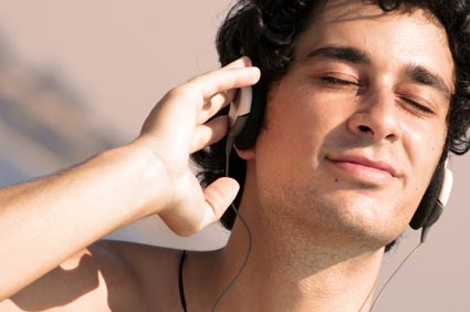 Junger Mann, der Musik mit einem Kopfhörer genießt.