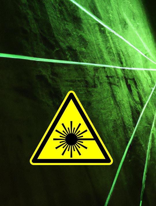 Dunkle Betonwand mit grünen Laserstrahlen und Laserpiktogramm