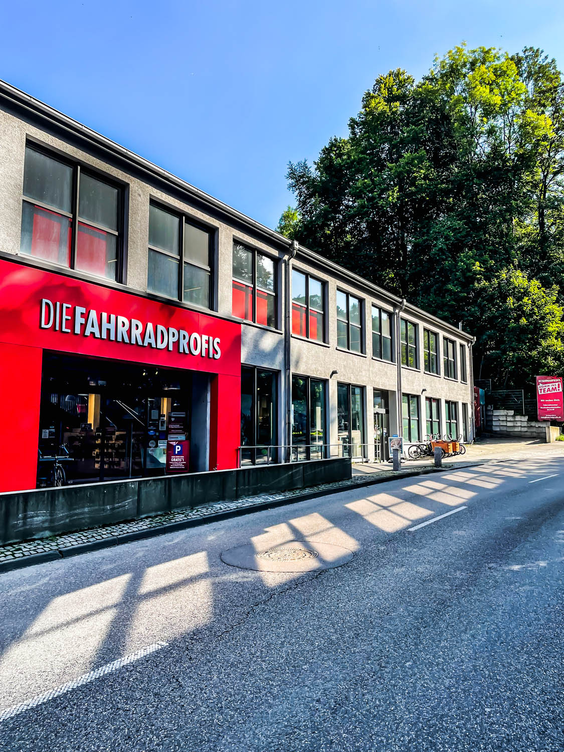 Außenansicht der Fahrradprofis-Filiale Ravensburg mit rotem Schaufenster und Firmenschriftzug an der Straße