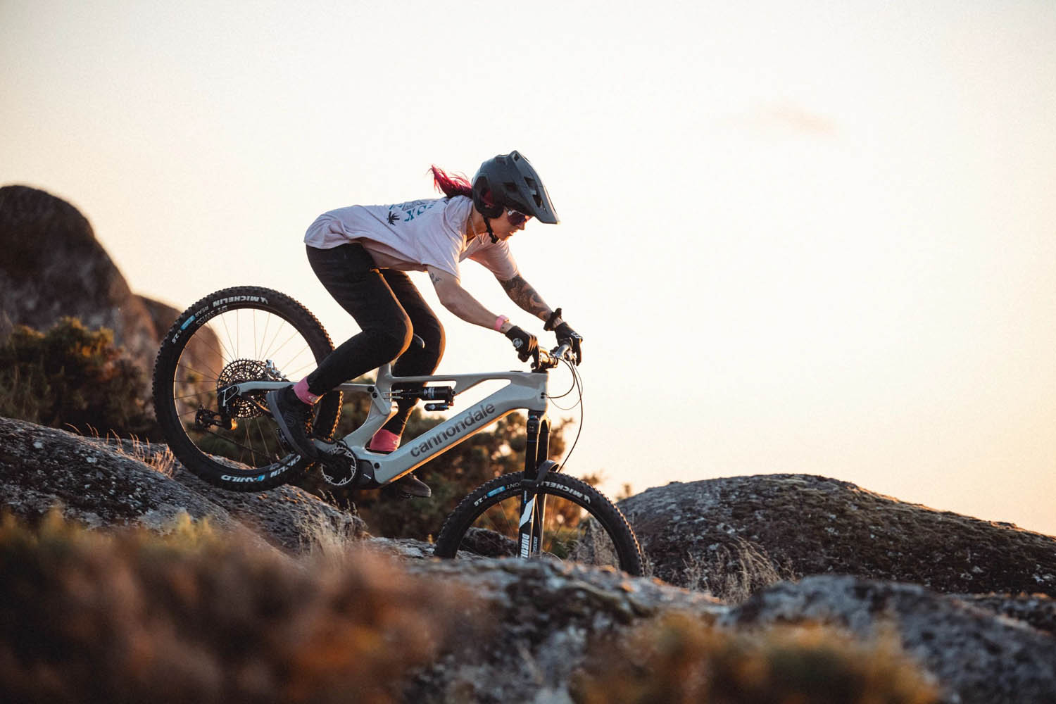 Mountainbiker auf einem E-Mountainbikerin Seitenansicht im felsigen Gelände