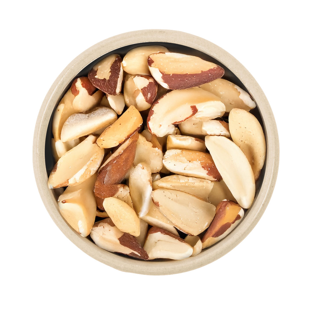 Nahaufnahme eines hellen Schälchens, gefüllt mit geschälten Paranusskernen auf weißem Hintergrund