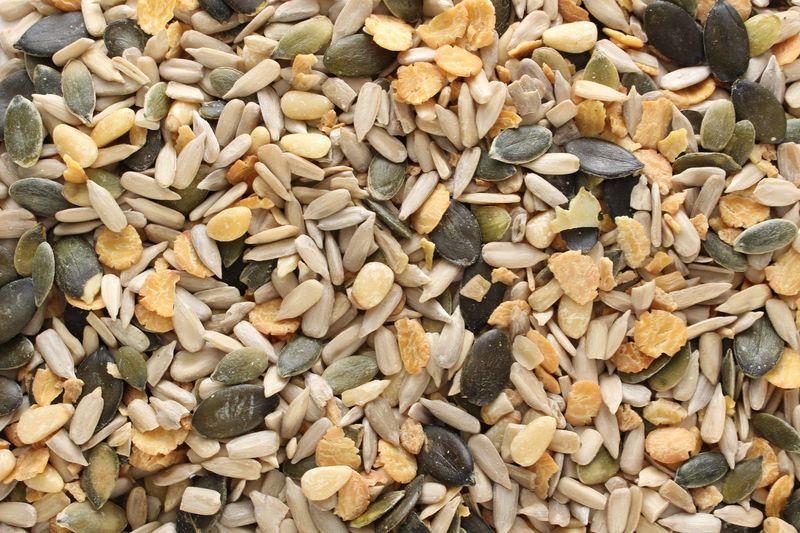 Nahaufnahme eines Saatenmixes mit geschälten Sonnenblumenkernen, Kürbiskernen und gespaltenen gelben Erbsen