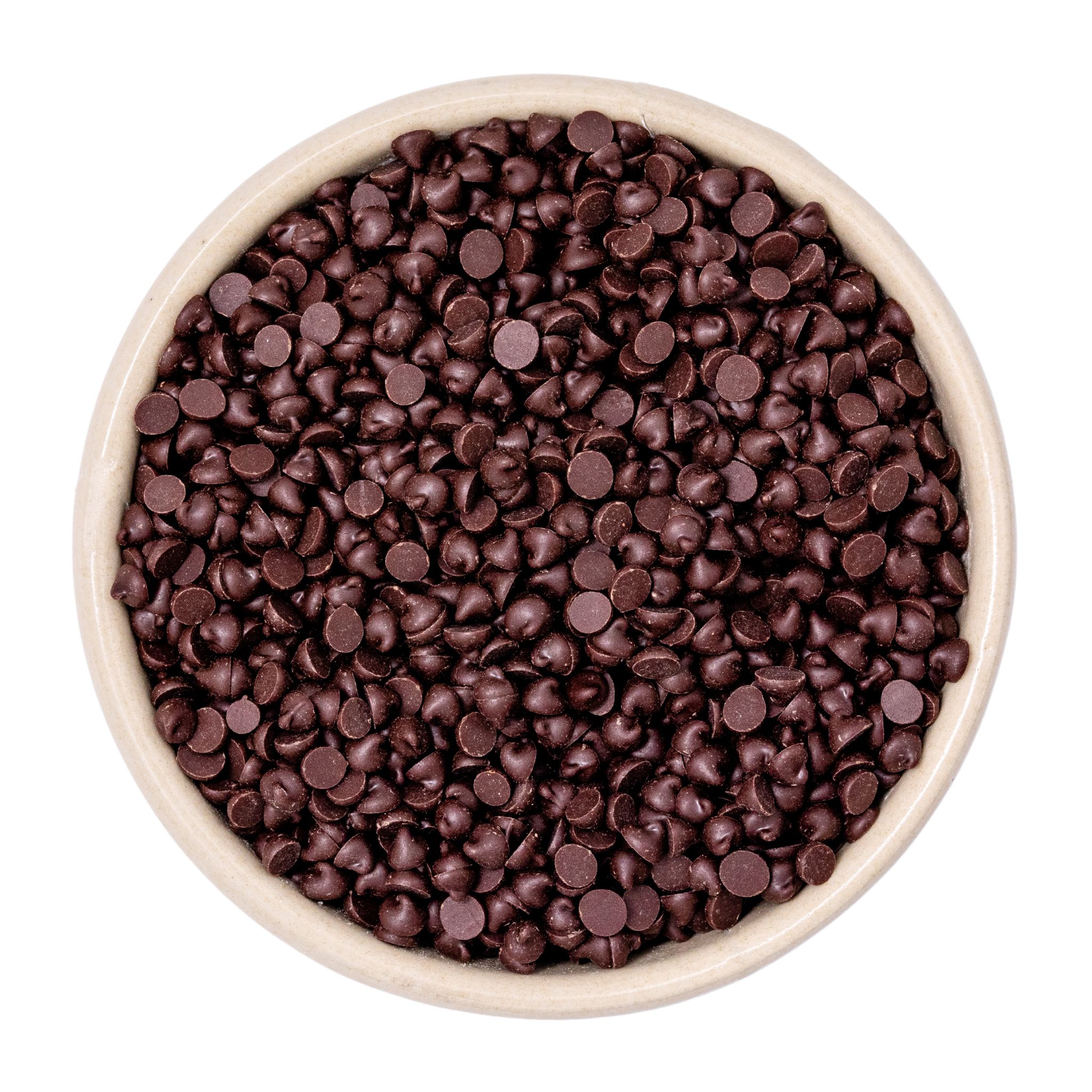 Schale gefüllt mit dunklen Schokoladenchips (Schokoladentropfen) auf weißem Hintergrund, Nahaufnahme