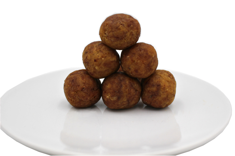 Sechs gebackene braune Bällchen auf weißem Porzellanteller, pyramidenförmig gestapelt