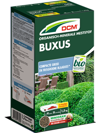 Groene verpakking van DCM organisch-minerale meststof voor buxus, met afbeelding van een buxushaag.