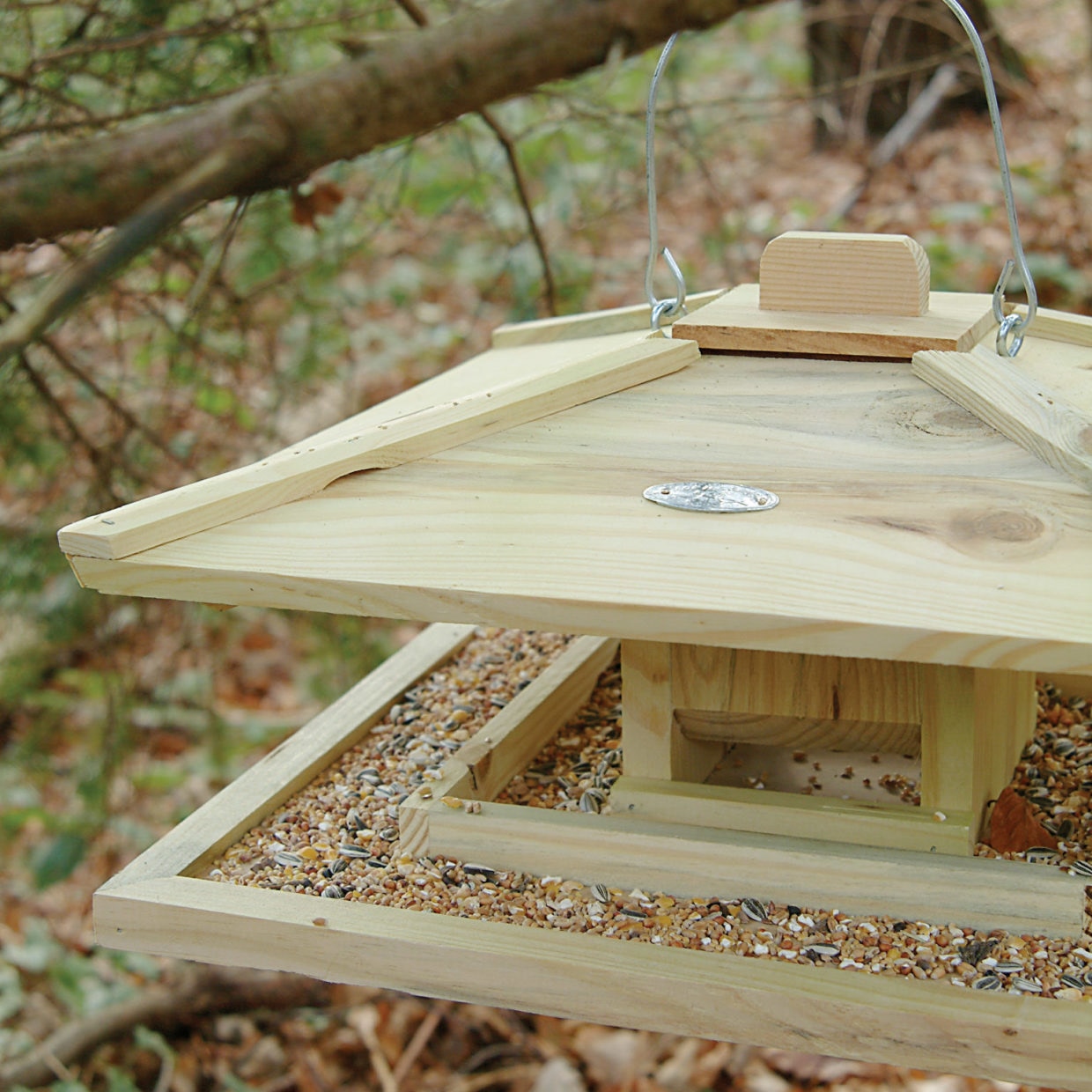 Houten vogelvoederhuis in de vorm van een Japans huis met een dakje en een open voederplateau.