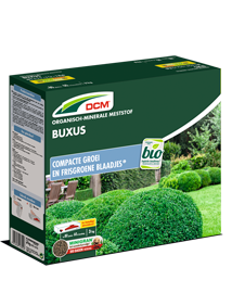 Groene verpakking van DCM Organische Meststof Buxus, 3 kg, met afbeelding van een buxushaag.