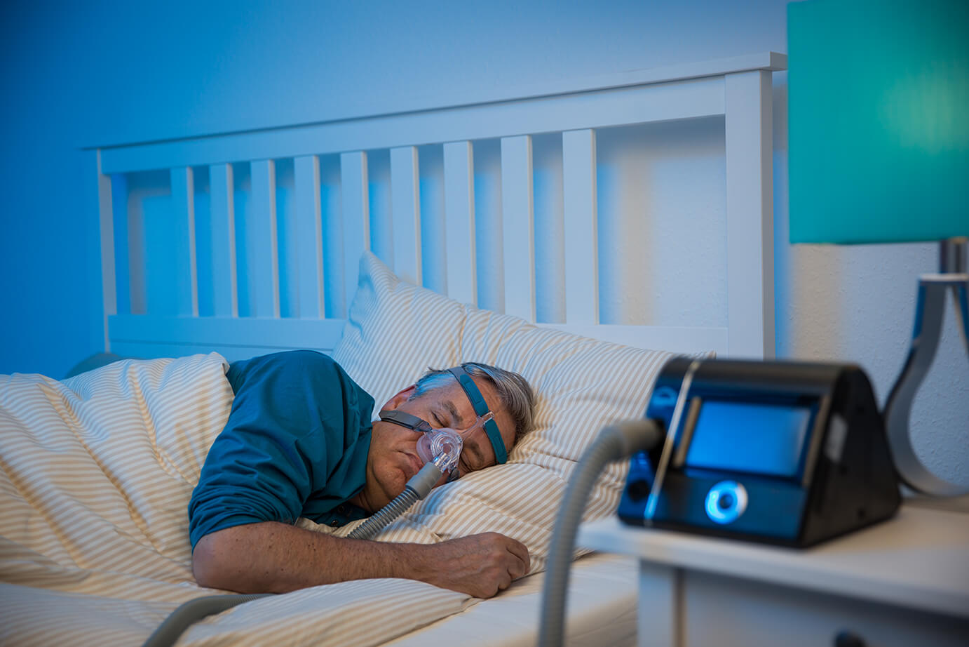 Schlafender Mann im Bett mit CARA Nasenmaske