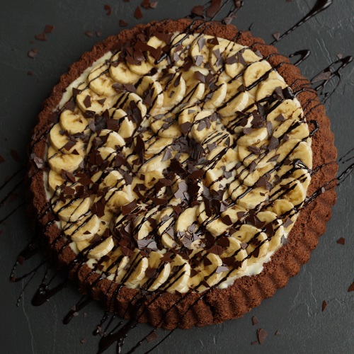 Ein schneller Obstboden, belegt mit Schokolade, Bananen und einer cremigen Vanille-Puddingfüllung – perfekt kombiniert für tollen Geschmack! Gebacken in der Lurch Obstbodenbackform.