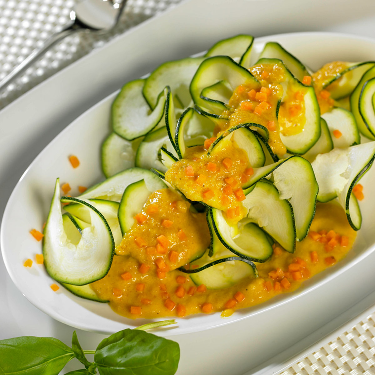 Zucchininudeln, liebevoll „Zoodles“ genannt, serviert mit einer frischen Zitronen-Karotten-Creme – ein leichtes, buntes Gemüsegericht mit Sommerfeeling.