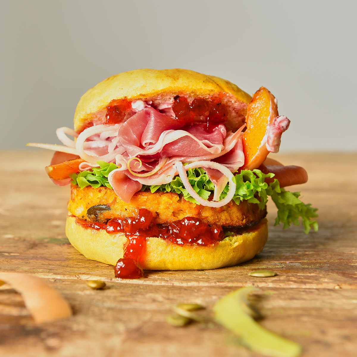 Herbstlicher Kürbis-Burger mit würzigen Buns, cremigem Kürbis-Patty, frischen Apfelspaghetti und optionaler Schinkenscheibe für ein harmonisch-süßes und herzhaftes Geschmackserlebnis.
