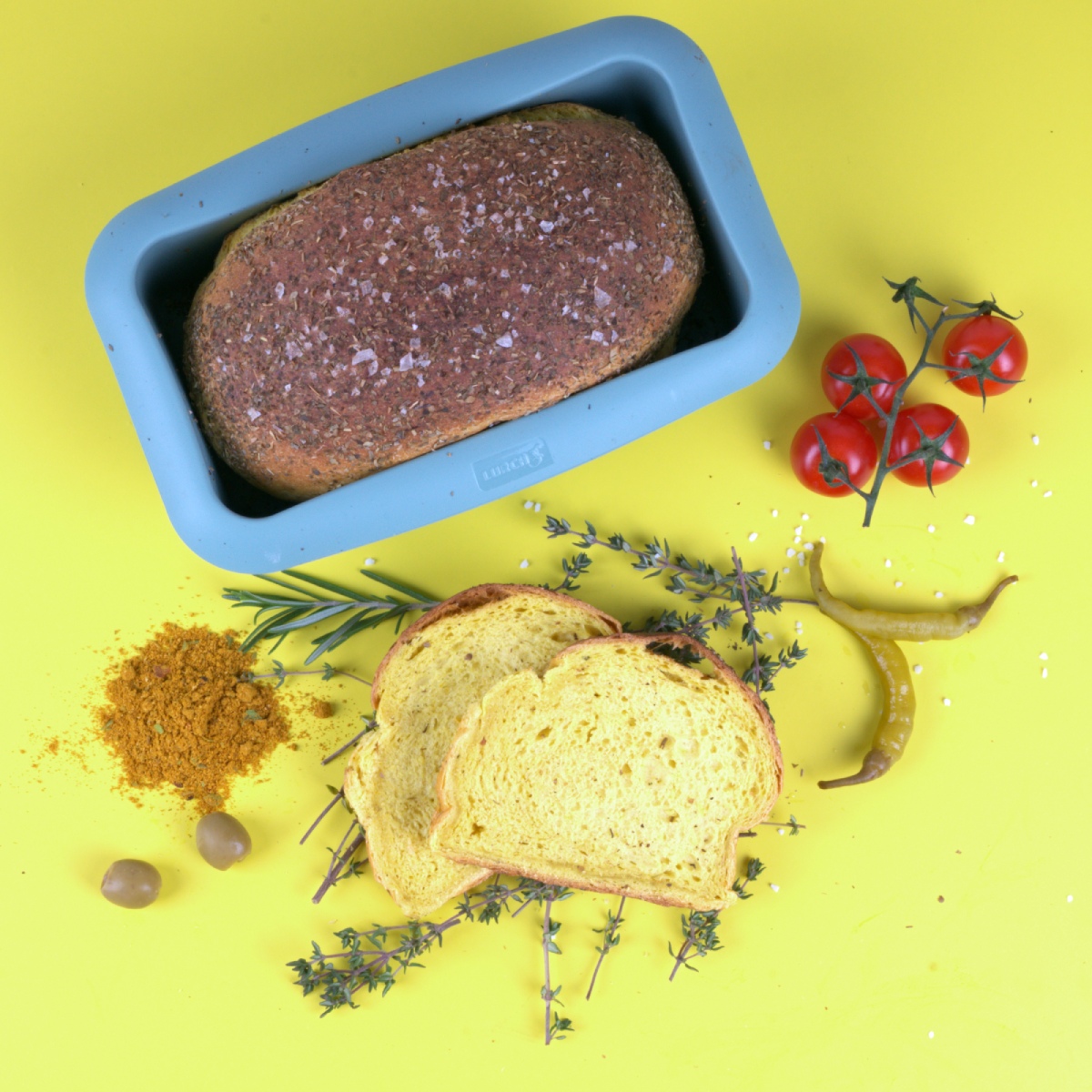 Kräuter-Curry-Weißbrot frisch in der Lurch Flexi Starter Brotbackform gebacken – lockere Scheiben mit aromatischer Würze, serviert auf einem Holzbrett.