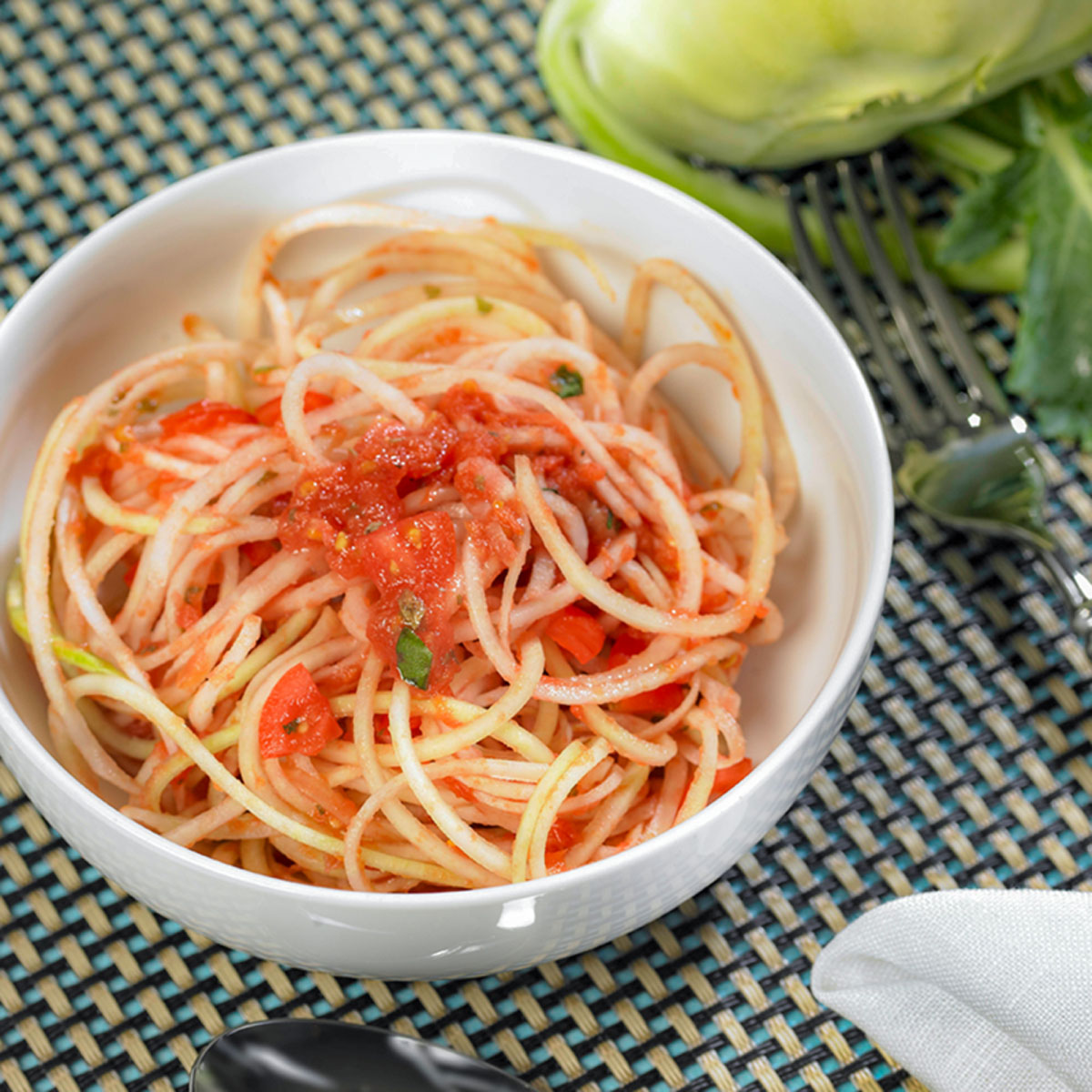 Kohlrabi-Spaghetti mit Tomatensoße und veganem Parmesan: Leicht, lecker und kreativ! Kohlrabi wird mit dem Lurch Spiralschneider zur Pasta, Nüsse zum „Parmesan“ – die Soße bleibt klassisch italienisch.