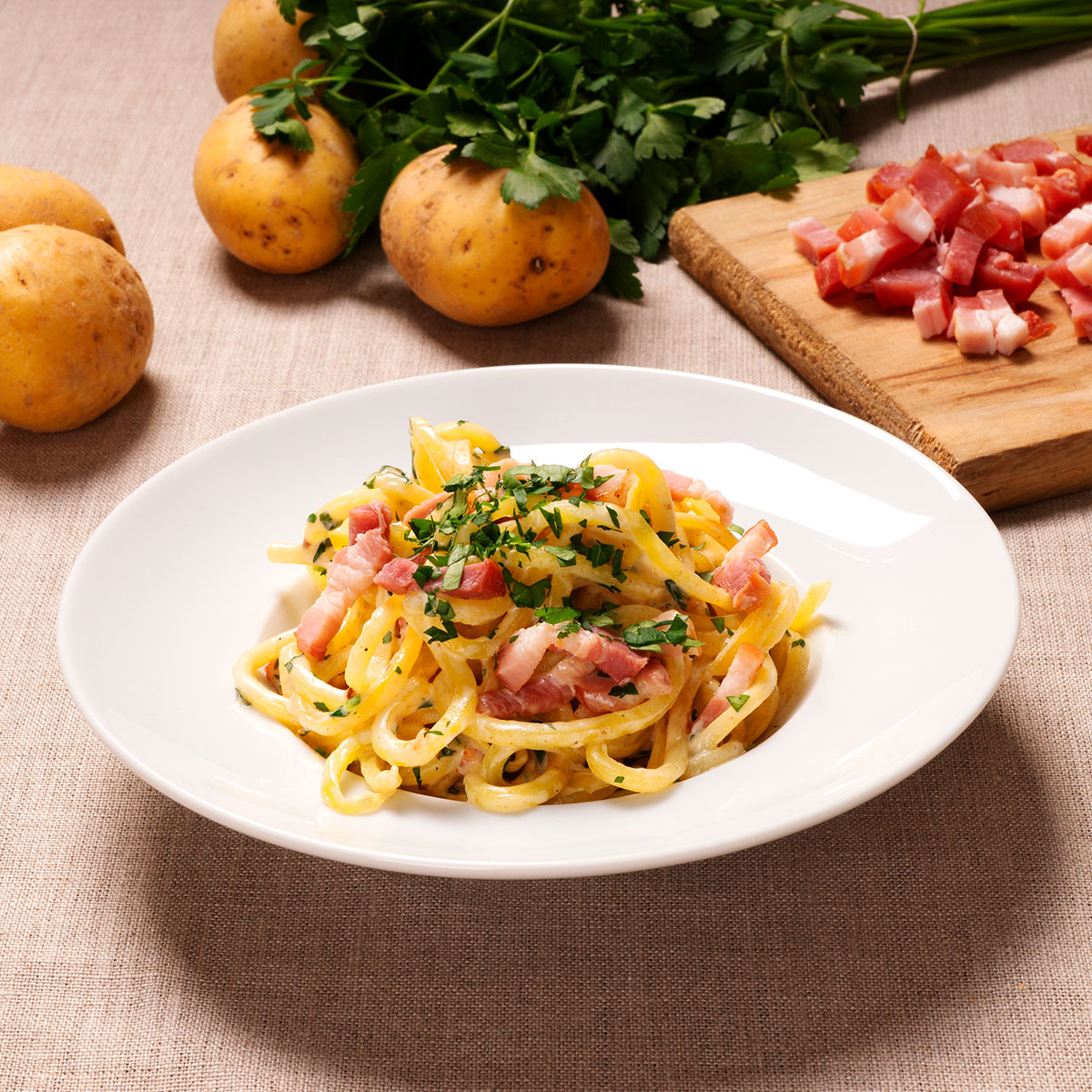 Kartoffelspaghetti in cremiger Sauce mit kross gebratenem Bacon.