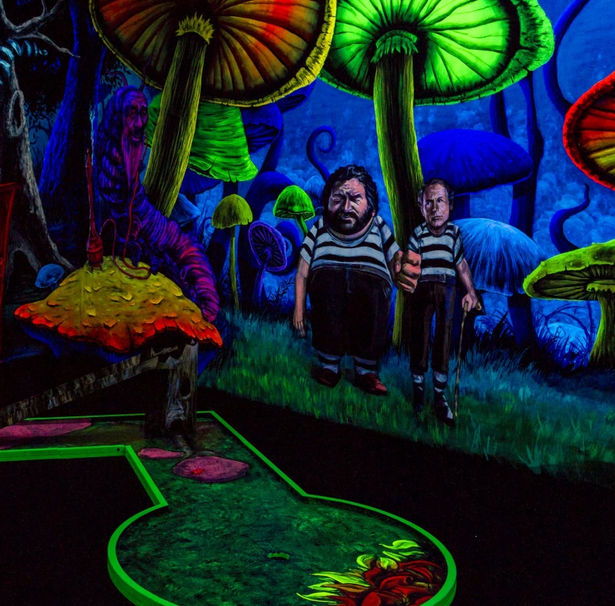 Eine Schwarzlicht-Minigolfbahn mit einer surrealen, märchenhaften Waldlandschaft. Überdimensionale, leuchtend bunte Pilze ragen über die Bahn hinaus. Zwei mysteriöse Figuren in gestreiften Outfits stehen im Zentrum der Szene, umgeben von einer dunklen, ve