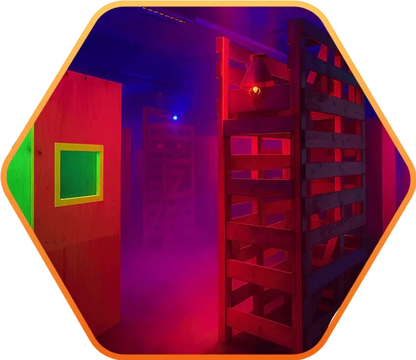 Innenansicht einer Lasertag-Arena in Oldenburg mit Holzwänden, rotem und blauem Licht sowie Nebel.