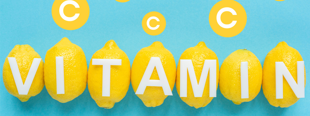 Text: Auf blauem Hintergrund gelbe Zitronen. Buchstaben liegen auf Zitronen. Wort Vitamin. I Punkte, der Buchstabe C. 