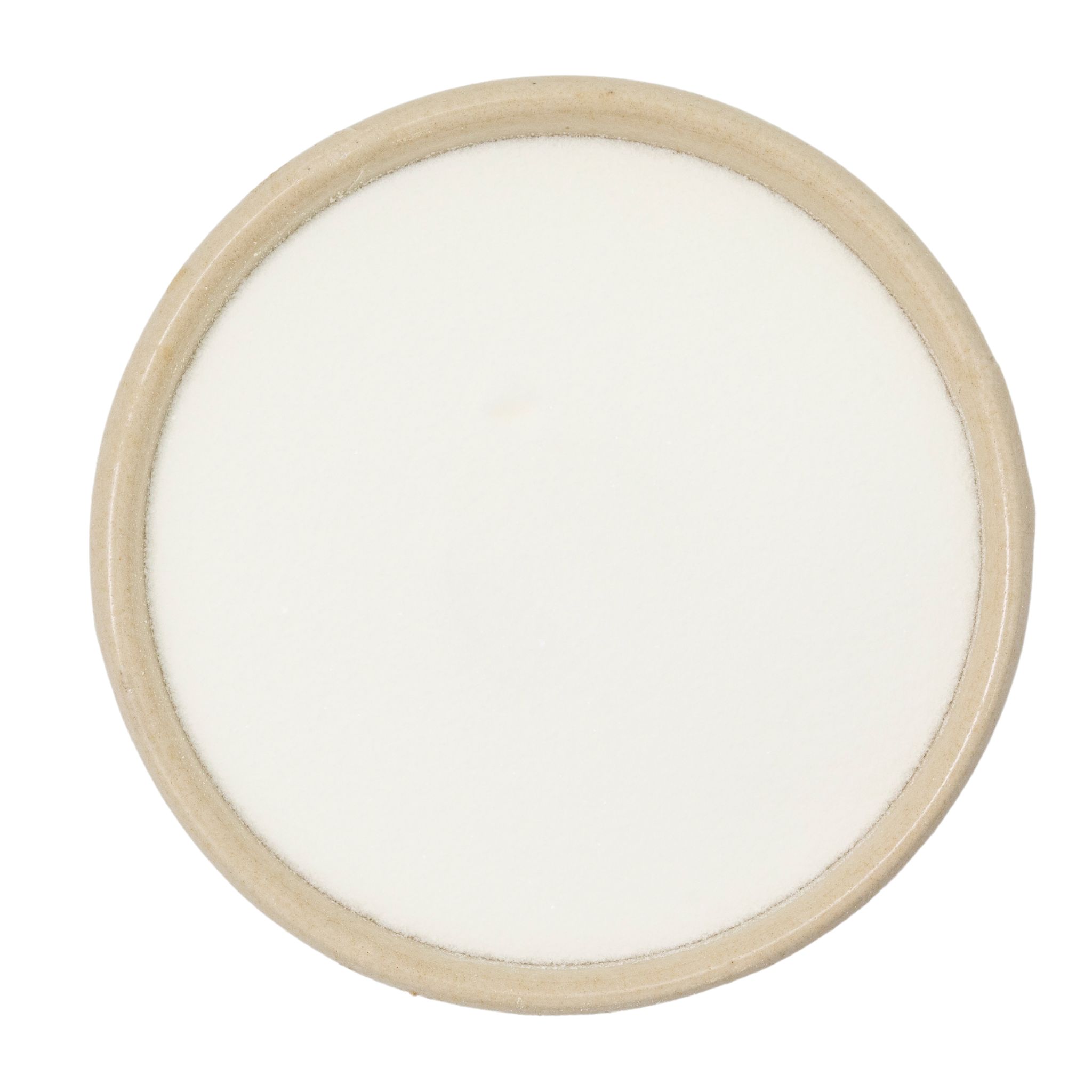 Billede set fra oven af hvidt stearinlys i rund beige keramisk beholder på hvid baggrund
