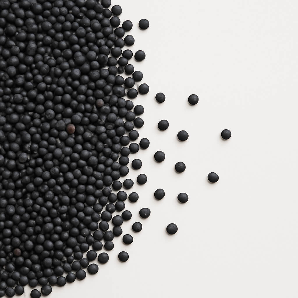 Black spherical pellets scattered on white background