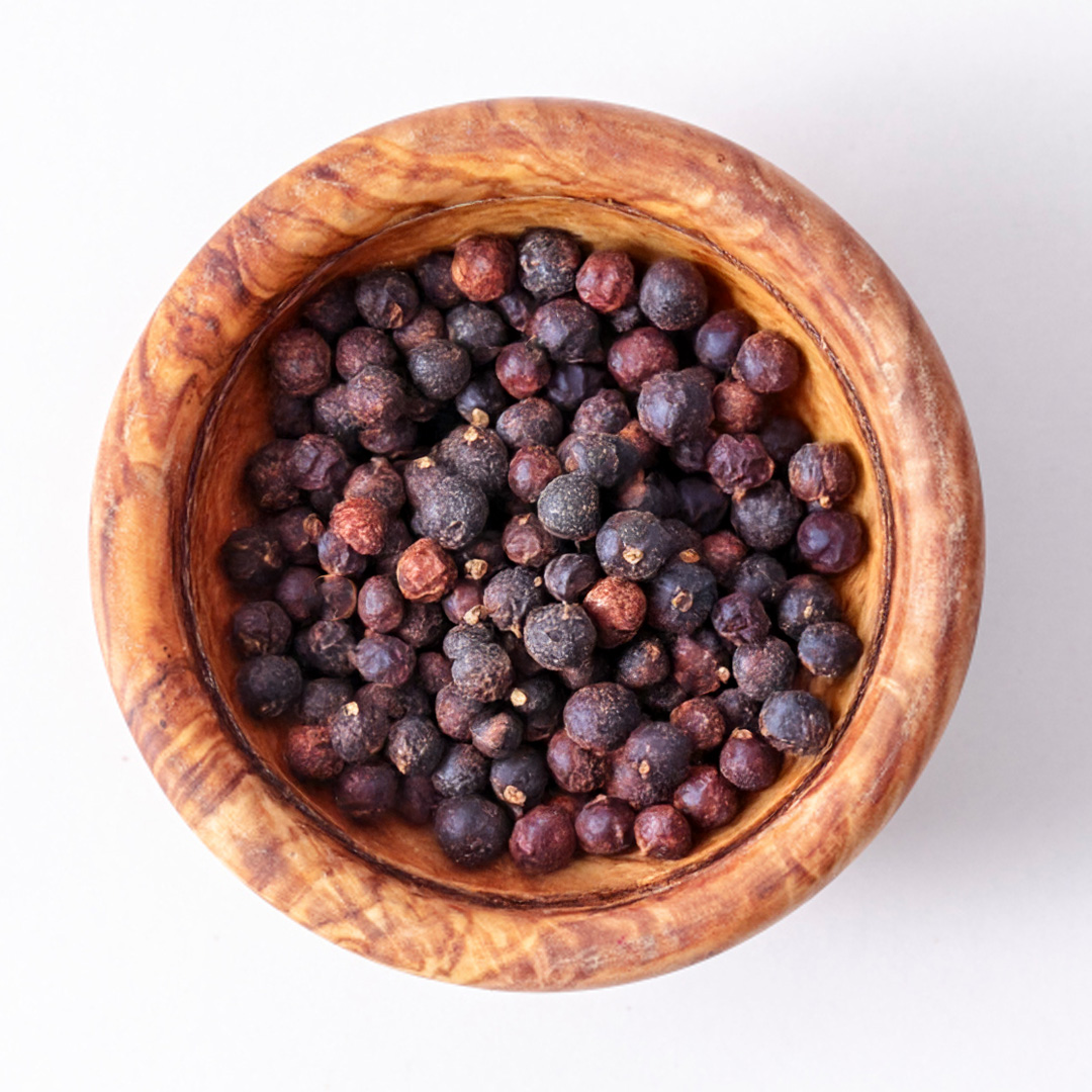 Draufsicht auf Wacholderbeeren in einer rustikalen Holzschale