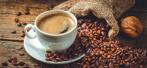 Kop kaffe med ristede bønner på træbord