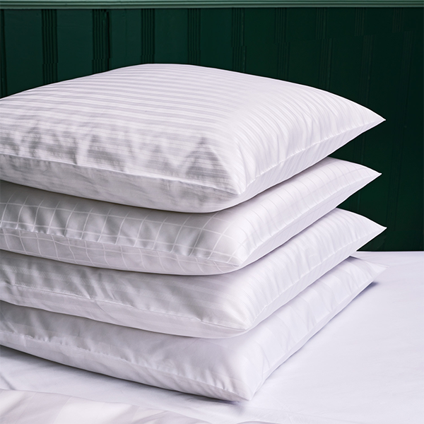 Kissenstapel Fischbacher Kissenbezug weiß vor dunklem Hintergrund 