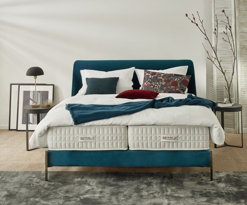 Treca Paris Boxspringbett Treca Betten in Dunkelblau mit weißer Bettwäsche in hellem Raum