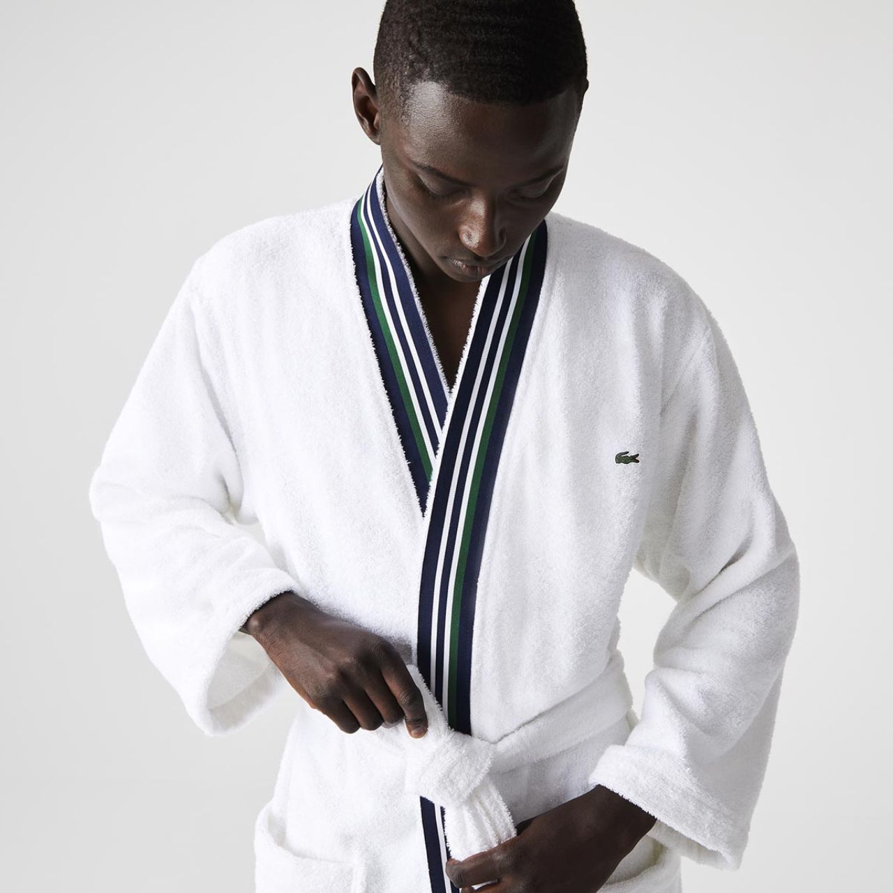 Mann in weißem Lacoste Bademantel