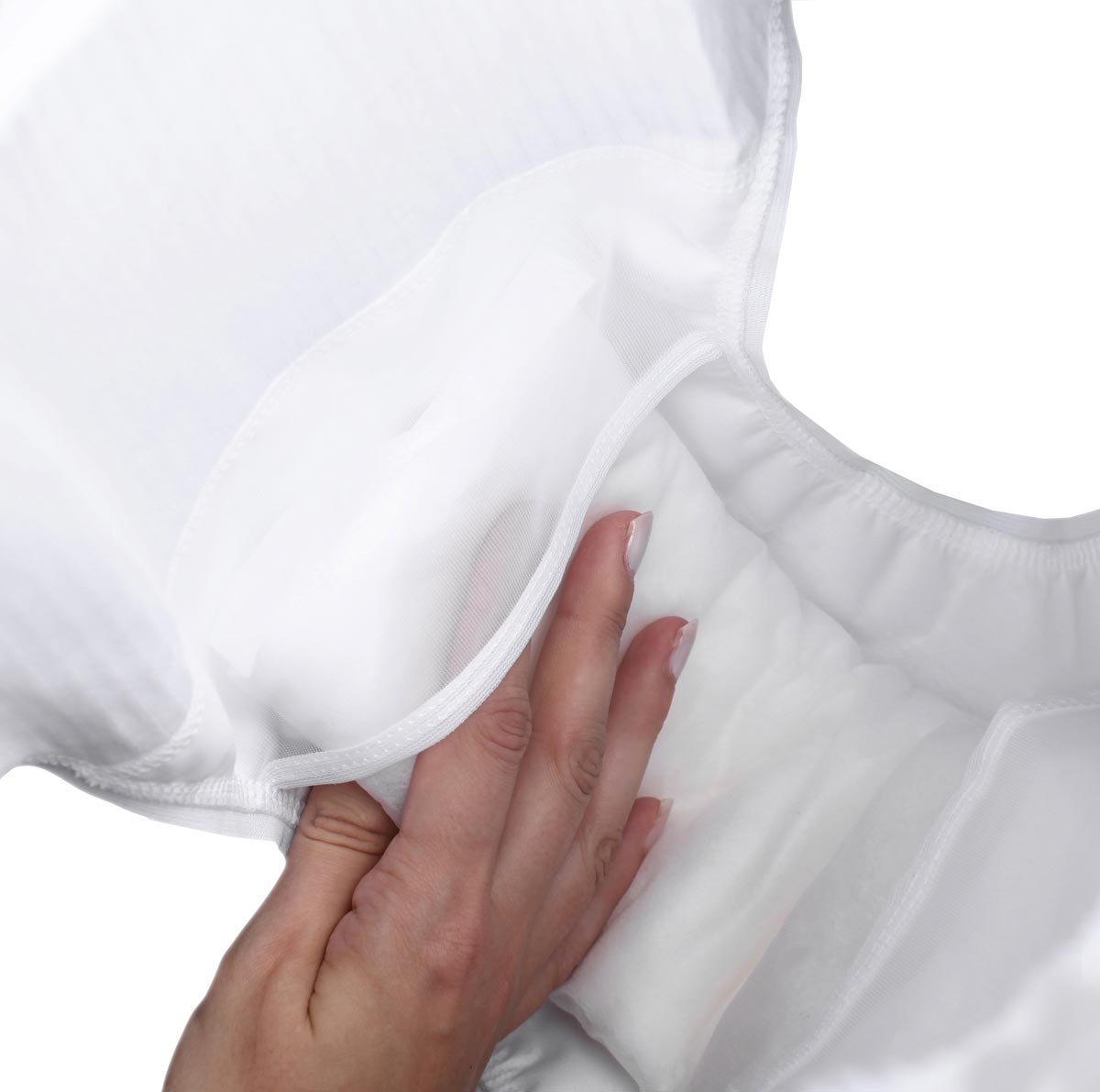 Eine Hand greift in einen weißen Inkontinenzartikel, der eine elastische Tasche hat. Innen sind weiche, saugfähige Schichten sichtbar, die für zusätzliche Absorption sorgen. Der Hintergrund ist schlicht und weiß.