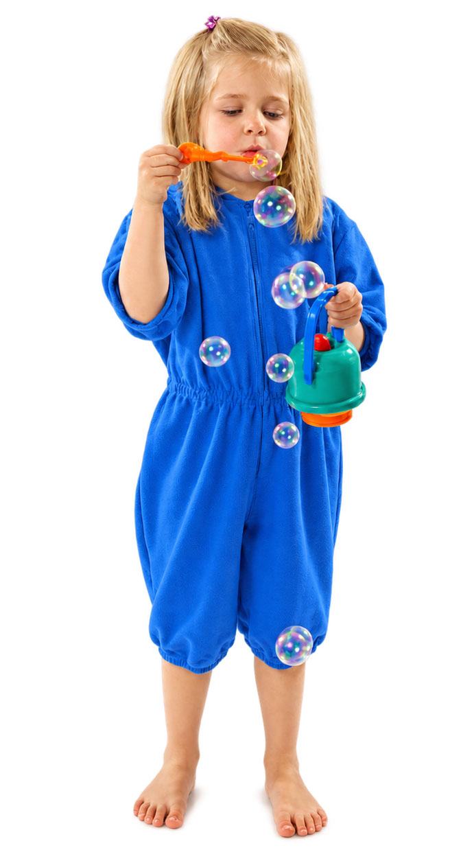 Ein Mädchen in einem blauen Overall bläst Seifenblasen mit einer orangefarbenen Seifenblasenröhre. In der anderen Hand hält es einen grünen Seifenblasenbehälter. Der Hintergrund ist weiß.
