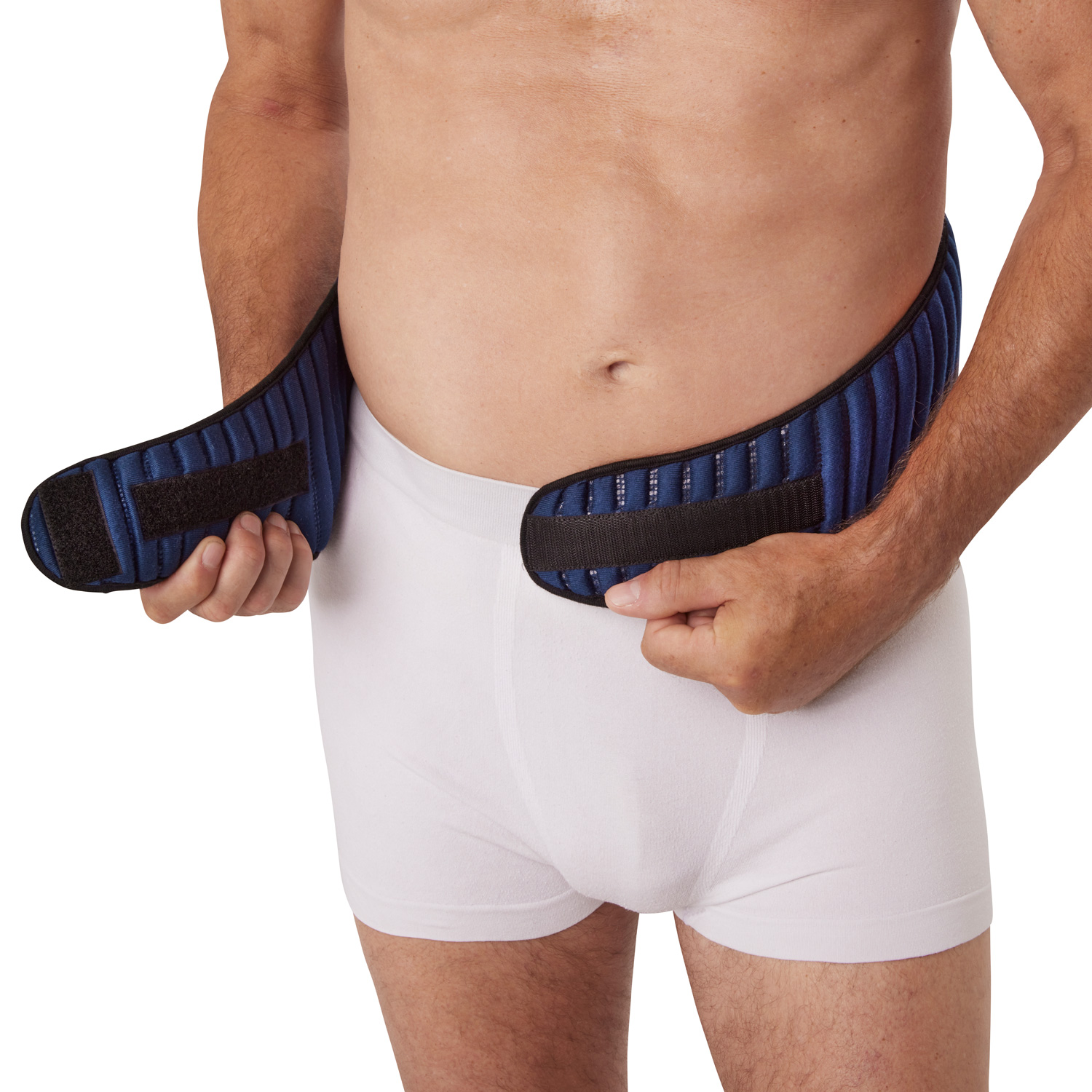 Ein Mann trägt einen elastischen, blauen Bauchverband, den er mit beiden Händen hält. Er trägt weiße Unterwäsche und befindet sich vor einem neutralen Hintergrund.