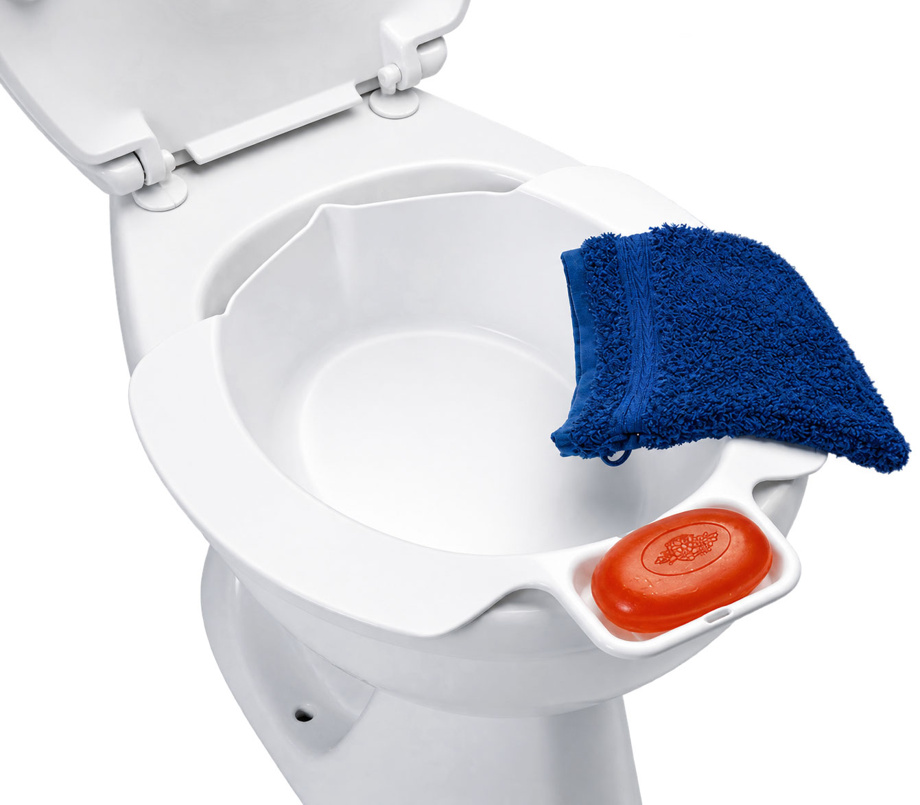 Eine weiße Toilettenschüssel ist geöffnet. Auf dem Rand liegt ein orangefarbener Seifenblock neben einem blauen Handtuch aus Frottee. Der Hintergrund ist neutral und hell.