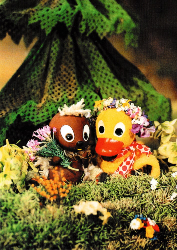 Postkarte "Unser Sandmännchen: Pittiplatsch und Schnatterinchen mit Blumen" Postkarte "Unser Sandmännchen: Pittiplatsch und Schnatterinchen mit Blumen"